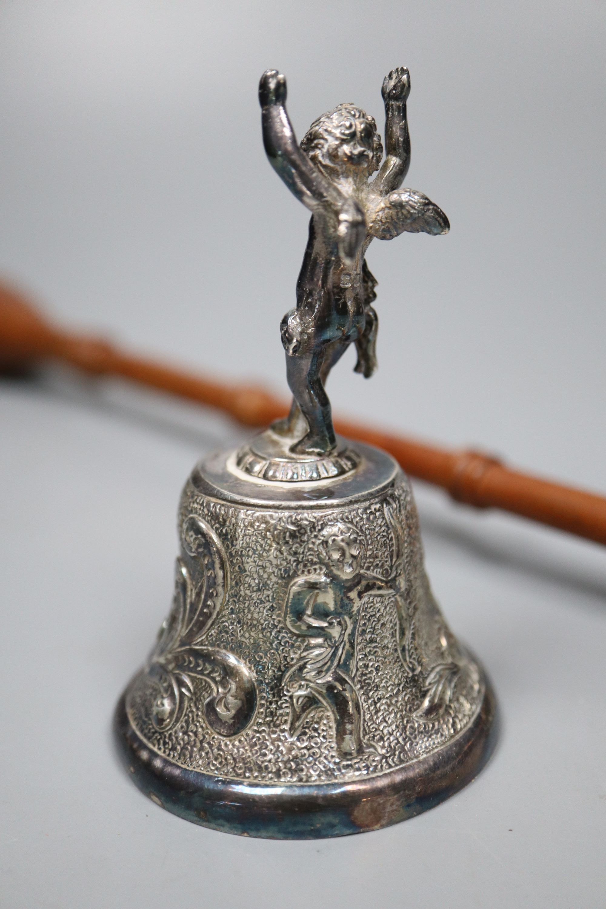 A modern silver table bell with putti handle, and a modern silver and turned wood handle candle snuffer,